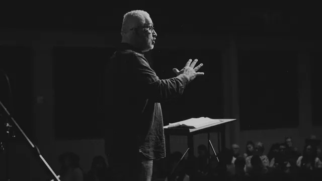 A speaker addressing a seated congregation